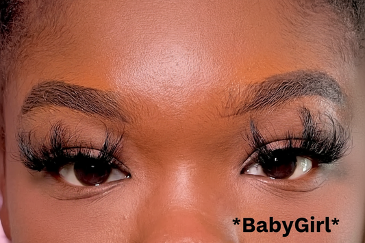 Close-up of a person's eyes with long eyelashes and dark brown eyebrows.