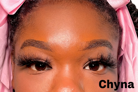 Close-up of a person with pink headband, lashes and makeup